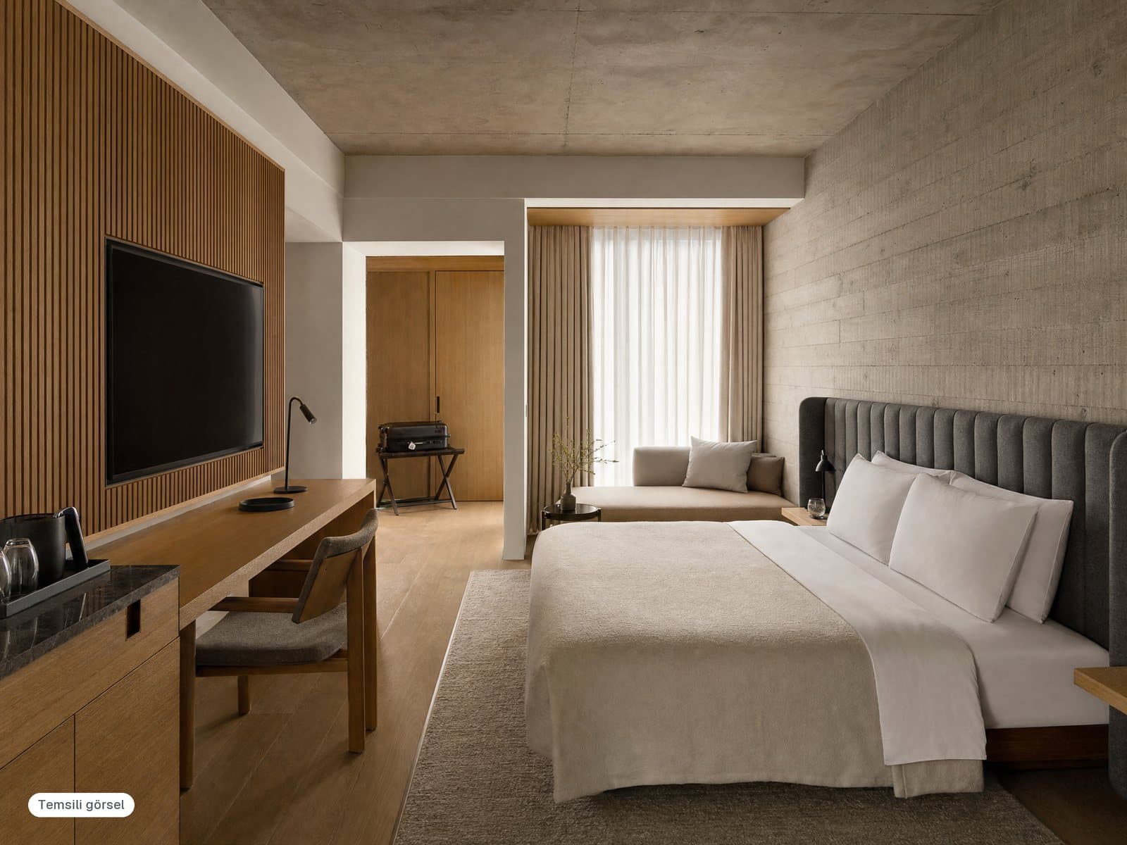 King yatak, çalışma masası ve TV paneli olan modern bir otel odası (temsili görsel)